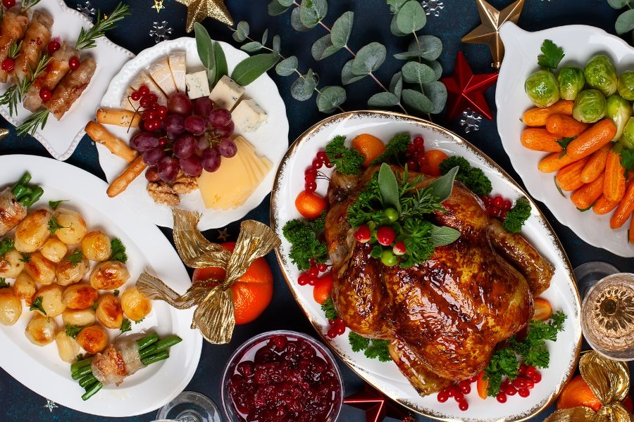 spread of Christmas foods on white plates with gold and green accents