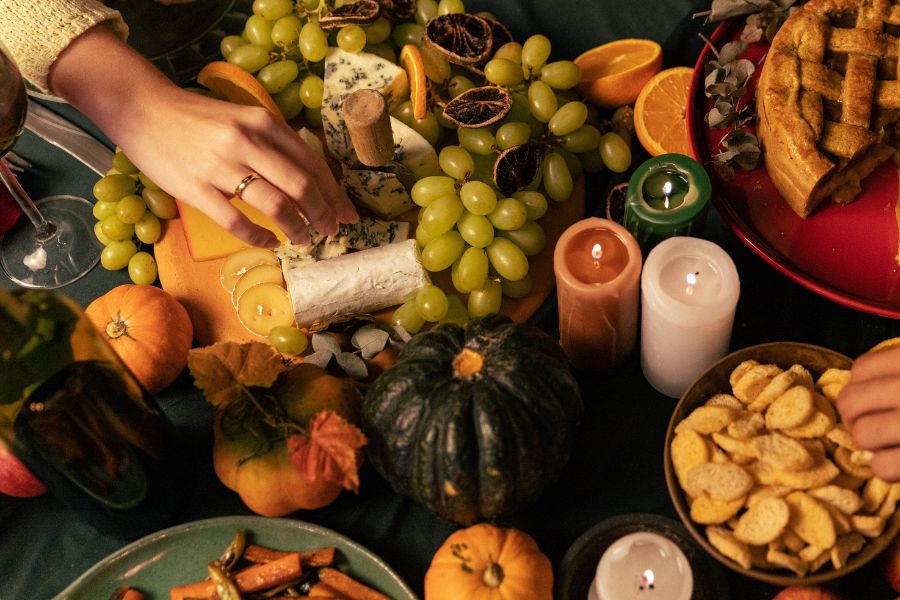 spread of autumnal foods, pumpkins, and candles