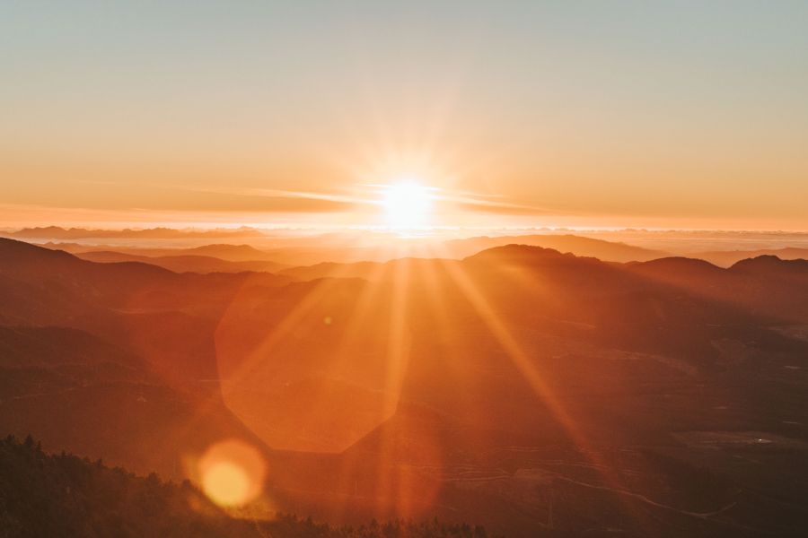 Sun setting over mountain range